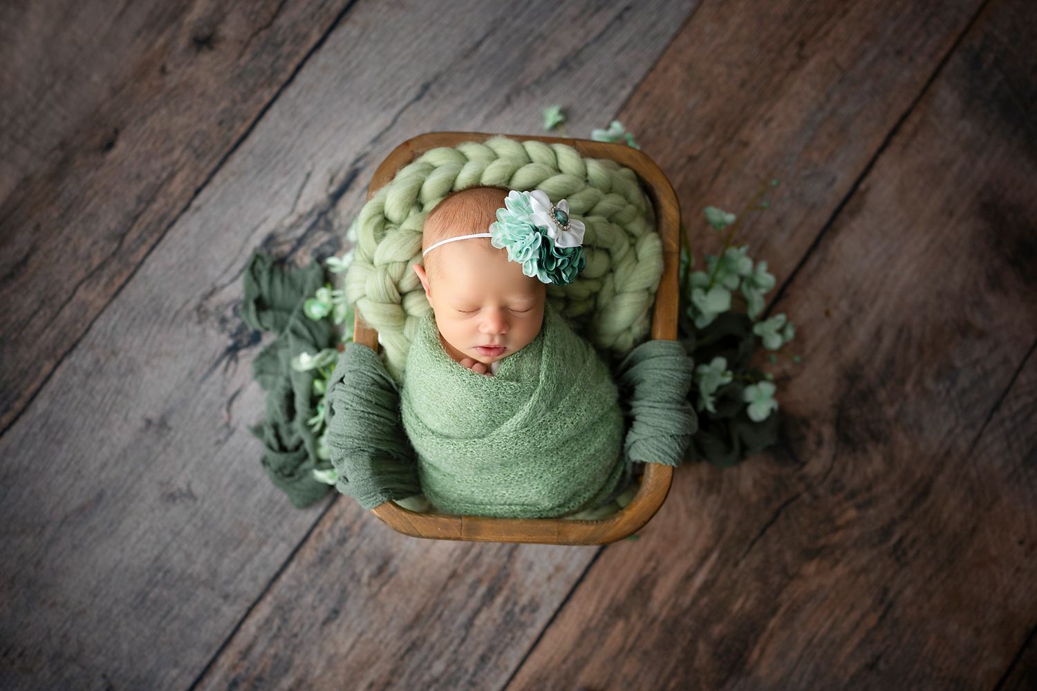 Newborn sleeping in a prop basket