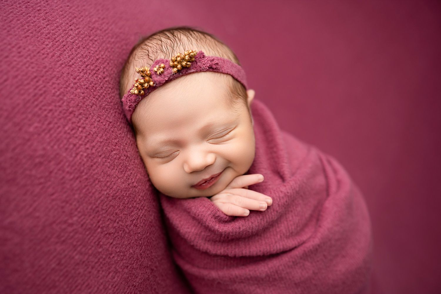 Newborn posed on a wooden bed prop